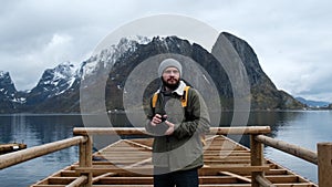 Professional photographer male taking photo of valley with DSLR wearing backpack photographing scenic landscape nature