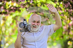 Professional photographer. Pension hobby. Senior man photographer blooming trees background. Cameraman retirement