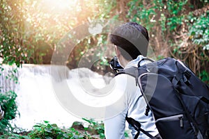 Professional photographer photographing waterfalls in the forest