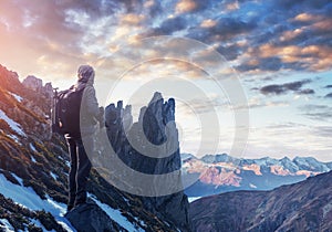 Professional photographer takes photos with big camera on peak of rock