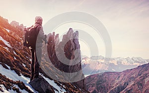 Professional photographer takes photos with big camera on peak of rock