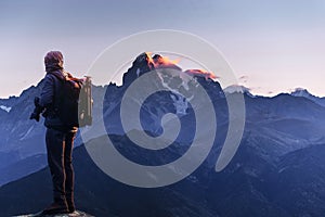 Professional photographer takes photos with big camera on peak of rock