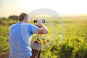 Professional photographer taking photo on savannah