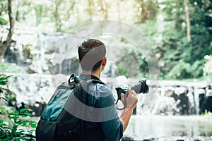 Professional photographers capture the beauty of nature with photographic equipment at a tropical waterfall.Concept of Photography