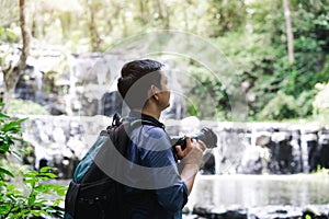 Professional photographers capture the beauty of nature with photographic equipment at a tropical waterfall.Concept of Photography