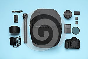 Professional photography equipment and backpack on turquoise, flat lay