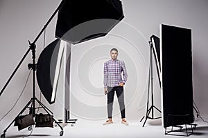 Professional photography studio showing behind the scenes lights. fashion handsome young man model at studio in the light flashes