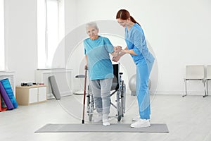 Professional physiotherapist working with elderly patient