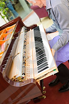 Professional piano technician removing keyboard for tuning repai