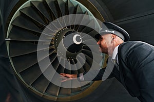 Professional pilot checking the turbofan engine before the take-off photo