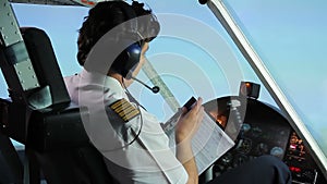 Professional pilot filling out flight papers while flying airplane, profession