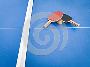 Professional ping pong rackets on a vibrant blue ping pong table, ready for game play