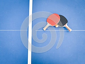 Professional ping pong rackets on a vibrant blue ping pong table, ready for game play