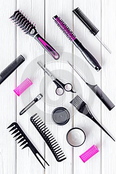 Professional pink accessories of hairdresser with combs on work desk wooden white background top view pattern