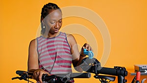 Professional placing bicycle on repair stand for checkup, studio background