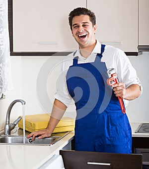 Professional plumber fixing problems in domestic kitchen