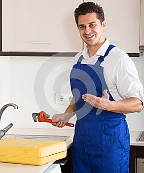 Professional plumber fixing problems in domestic kitchen