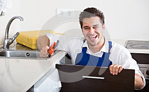 Professional plumber fixing problems in domestic kitchen