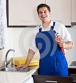 Professional plumber fixing problems in domestic kitchen