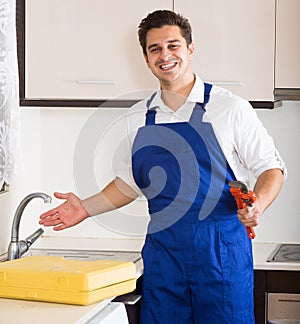 Professional plumber fixing problems in domestic kitchen