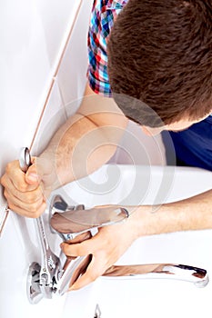 Professional plumber repairing a tap