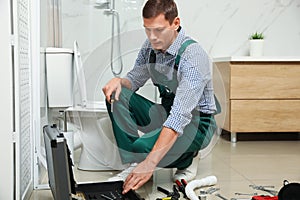 Professional plumber repairing toilet tank