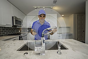 Professional plumber working inside of a modern kitchen