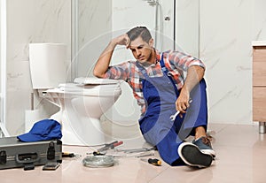 Professional plumber working with toilet bowl