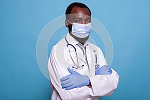 Professional portrait of physician in hospital uniform wearing laboratory coat and protective face mask