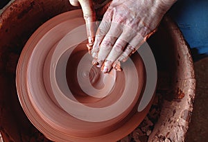 Professional potter making bowl