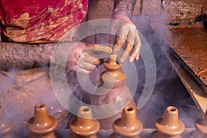 Professional potter making bowl in pottery workshop, studio