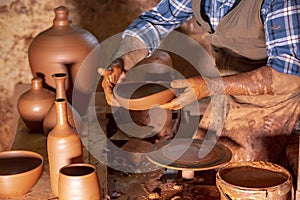 Professional potter making bowl in pottery workshop, studio