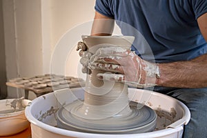 Professional potter making bowl in pottery workshop, studio