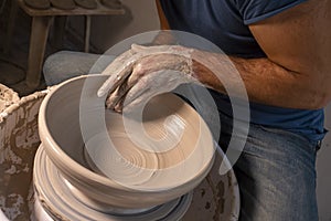 Professional potter making bowl in pottery workshop, studio