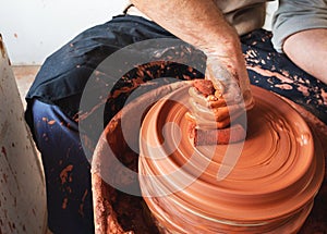 Professional potter making bowl in pottery workshop, studio