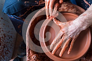 Professional potter making bowl in pottery workshop, studio