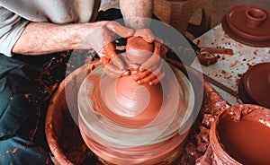 Professional potter making bowl in pottery workshop, studio