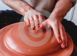 Professional potter making bowl in pottery workshop, studio