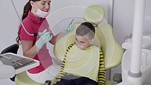 Professional procedure of child's tooth brushing with the special dental tools