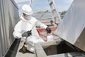 Professional in protective uniform, mask, gloves in the roof for cleaning