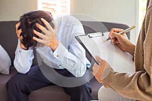 A professional psychiatrist holds a clipboard to note the details of the treatment for mental illness. Depression and photo