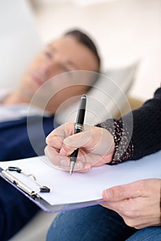 Professional psychologist making notes on therapy session