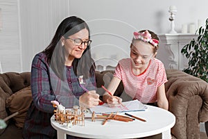 Professional psychologist with a teenage girl. Disclosing a child through a drawing. The method of work of a child psychotherapist photo