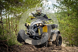 Professional quad biker rides in forest. Quad racing, ATV 4x4