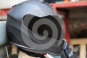 A professional racer in a black helmet and a white homologated suit sits in the sports seat of a car for drifting and racing photo