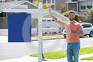 Professional realtor real estate agent with house for sale sign standing near residential property outside. Copy space.