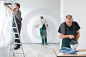 renovation crew painting walls of new build apartment