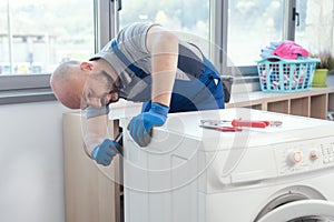 Professional repairman fixing a washer