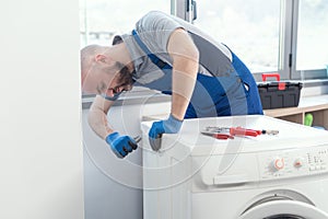 Professional repairman fixing a washer