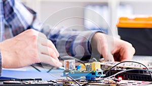 Professional repairman repairing computer in workshop